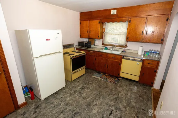 a kitchen with stainless steel appliances granite countertop a refrigerator a stove a sink and a microwave