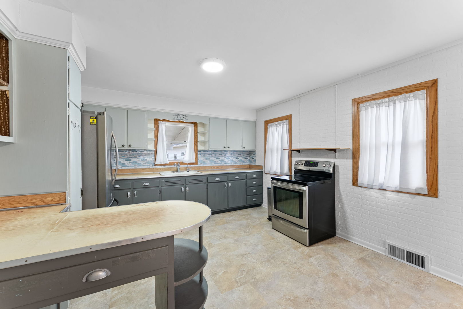 1419 113th Avenue Milan, IL 61264 - Photo 13 of 25 a kitchen with kitchen island a sink appliances cabinets and a counter top space