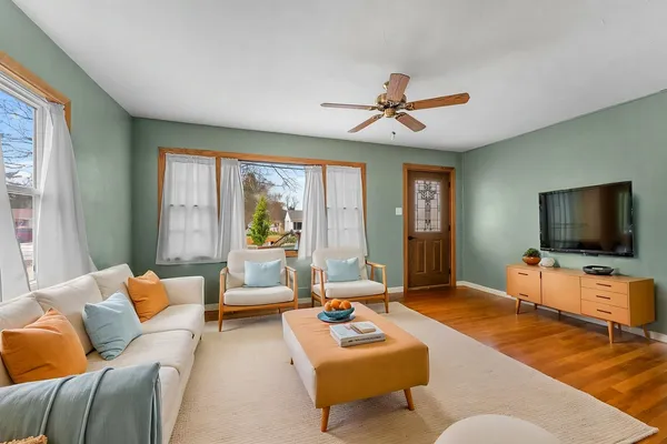 an empty room with chandelier fan and windows