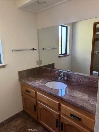 a bathroom with a granite countertop sink and a mirror