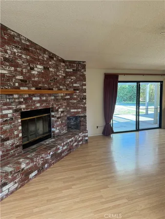 a view of an empty room with a fireplace and a window