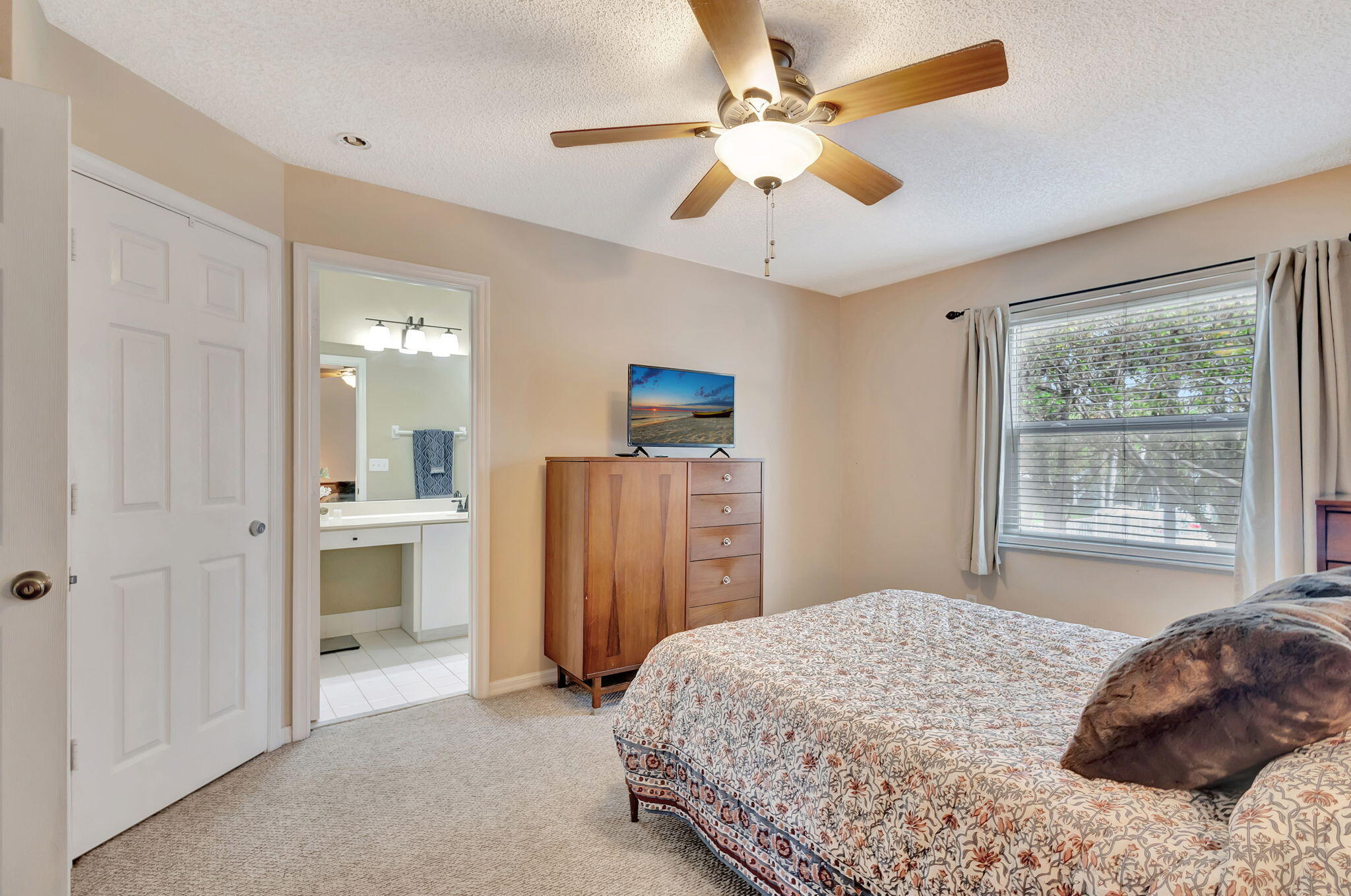 145 Timberwalk Trail Jupiter, FL 33458 - Photo 28 of 61 a bedroom with a bed and a chandelier