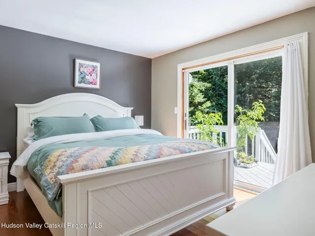 a bedroom with a bed and painting on the wall