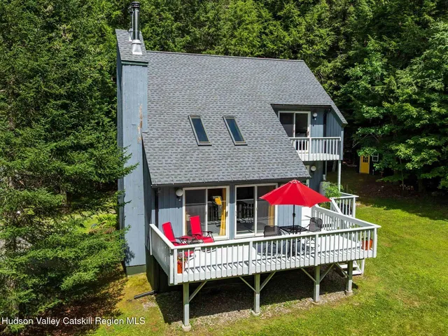 an aerial view of residential house with outdoor space and trees all around