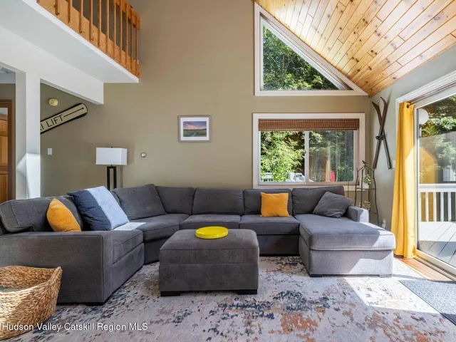 a living room with patio furniture and floor to ceiling windows