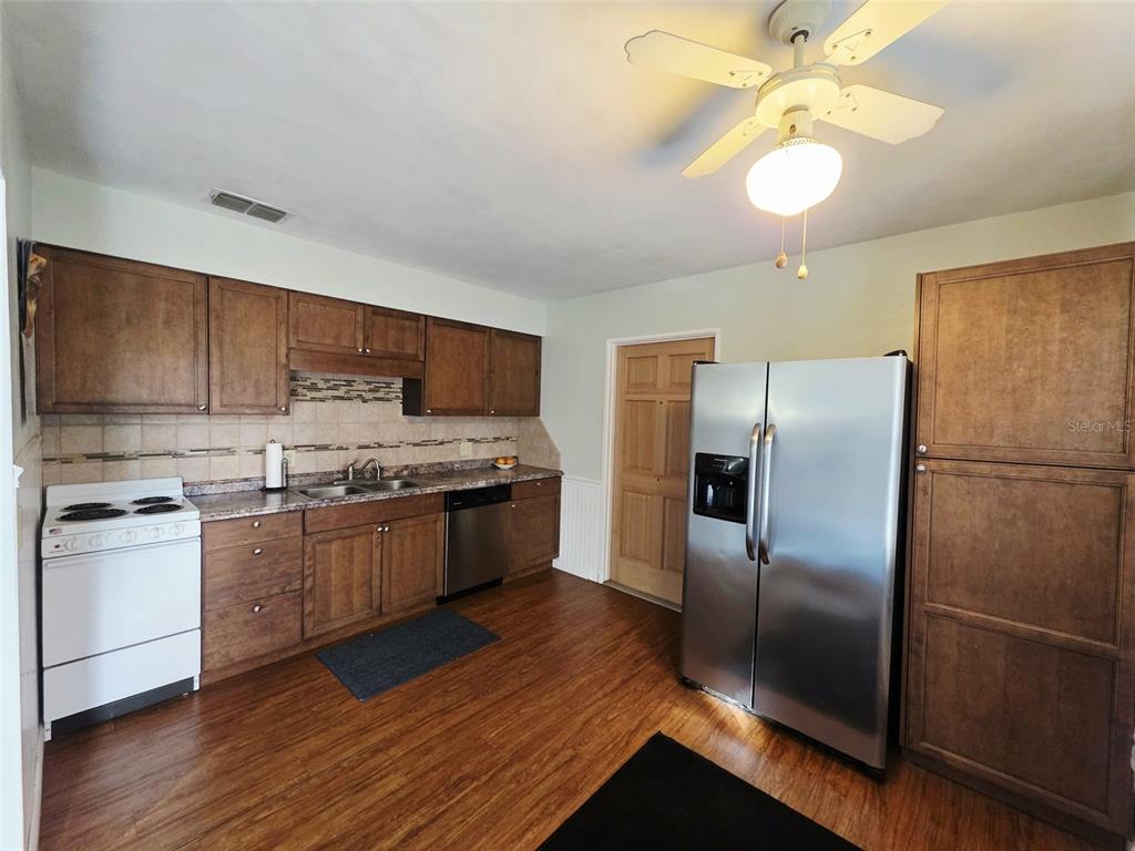 6309 Central Avenue New Port Richey, FL 34653 - Photo 6 of 18 a kitchen with stainless steel appliances granite countertop a refrigerator a stove a sink and a microwave