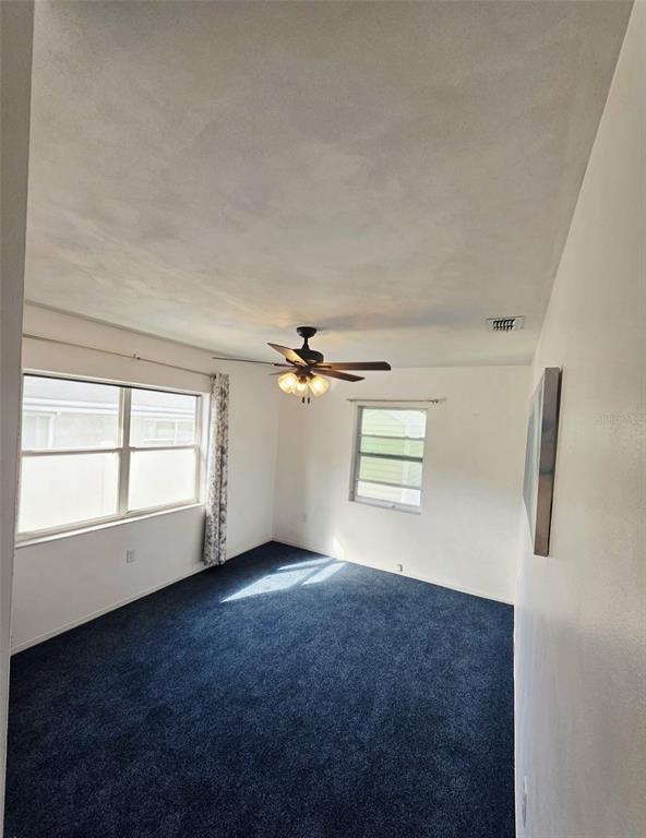 6309 Central Avenue New Port Richey, FL 34653 - Photo 9 of 18 an empty room with windows and ceiling fan view