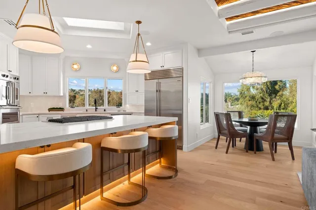 a dining room with furniture a chandelier and wooden floor