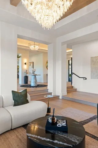 a dining room with furniture a chandelier and wooden floor