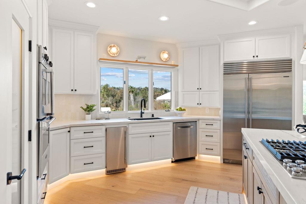 528 Flores De Oro Rancho Santa Fe, CA 92067 - Photo 23 of 75 a kitchen with white cabinets and appliances