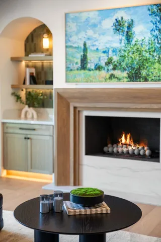 a living room with furniture a chandelier and a fireplace
