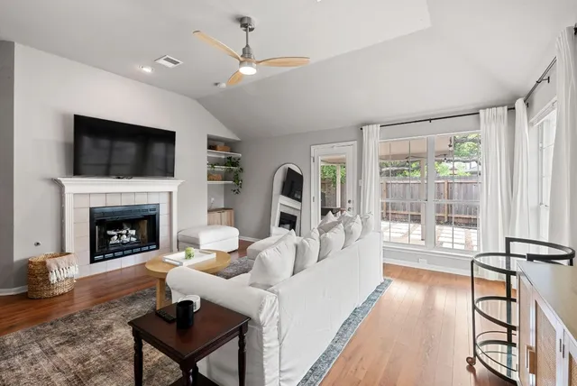 a living room with furniture a fireplace and a flat screen tv