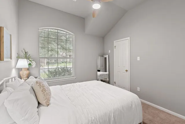 a bedroom with a bed and a couch with exposed radiator