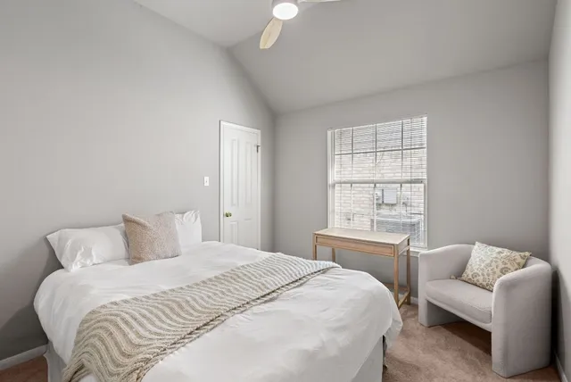 a bedroom with a bed window and a chandelier