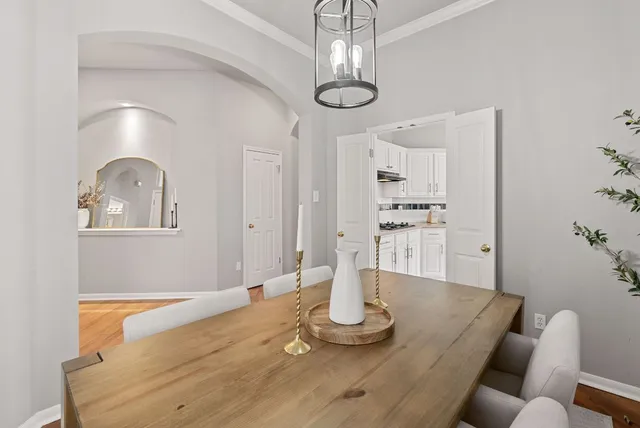 a view of a dining room with furniture a chandelier and wooden floor