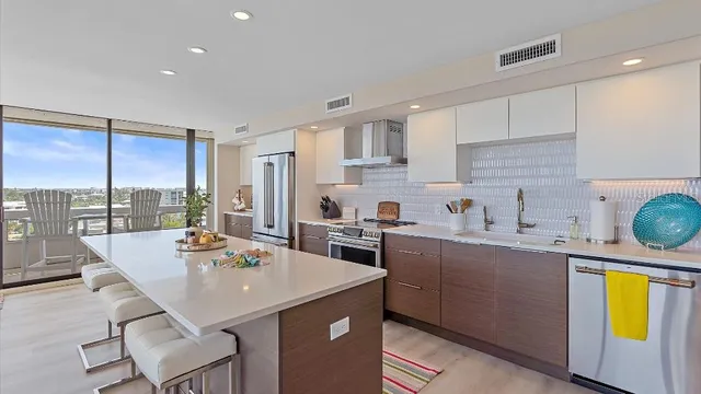 a kitchen with a sink a counter top space and stainless steel appliances