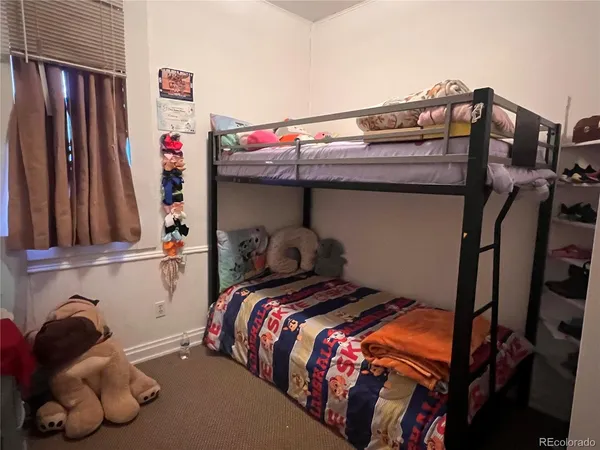 a bed sitting in a bedroom next to a window