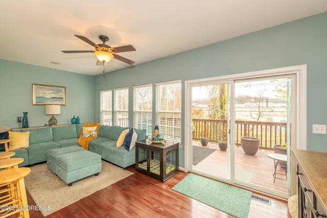 a living room with furniture and a large window with wooden floor