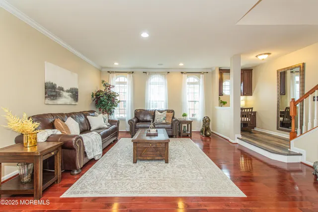 a living room with furniture wooden floor and a large window