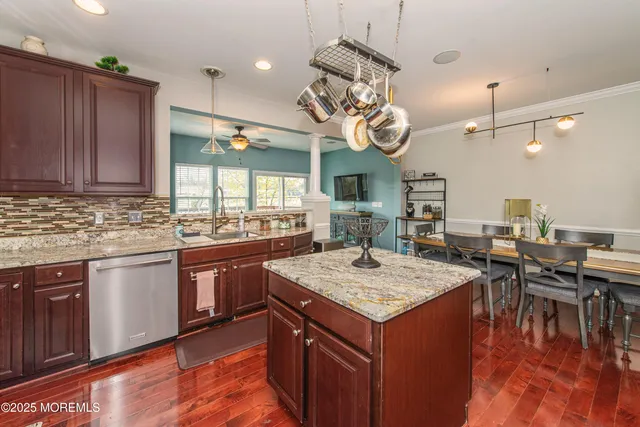 a kitchen with a stove a kitchen island a dining table and chairs with wooden floor