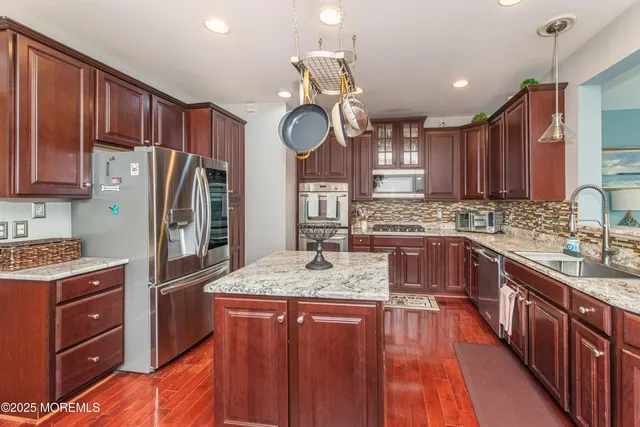 a kitchen with stainless steel appliances granite countertop wooden cabinets stove and refrigerator