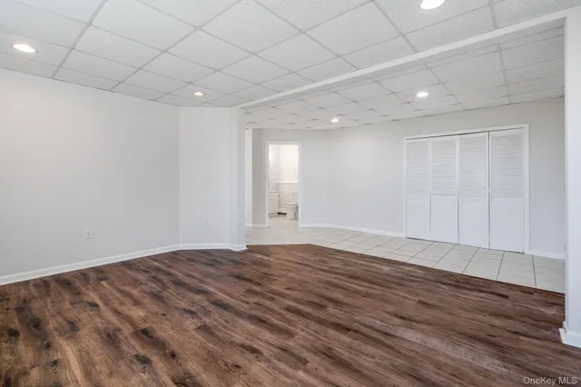 a view of a deck with large trees and wooden fence