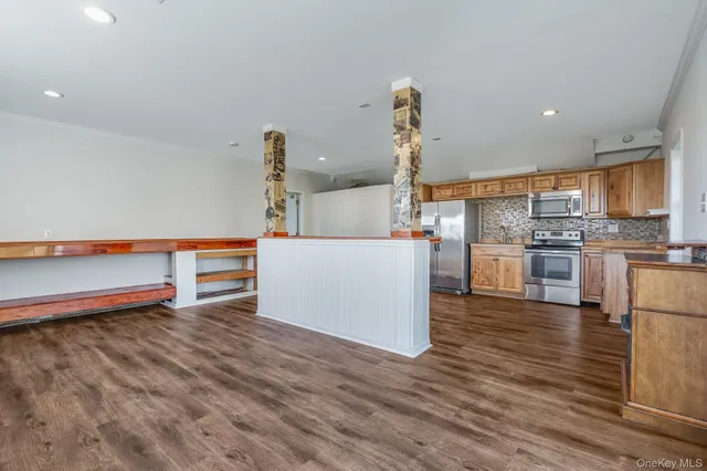 a view of a kitchen with wooden floor and a window
