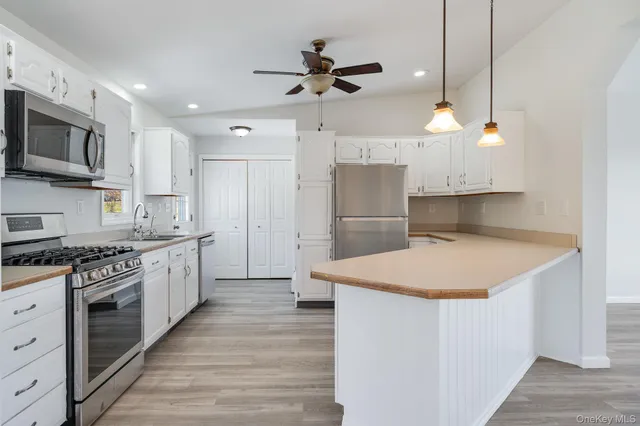 a kitchen with granite countertop a sink cabinets and stainless steel appliances
