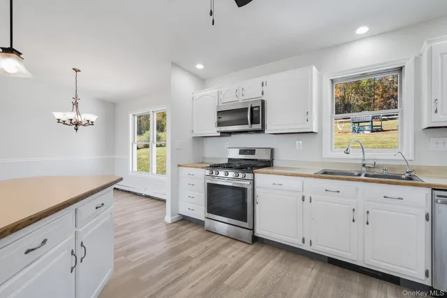 a kitchen with granite countertop white cabinets and a wooden floor