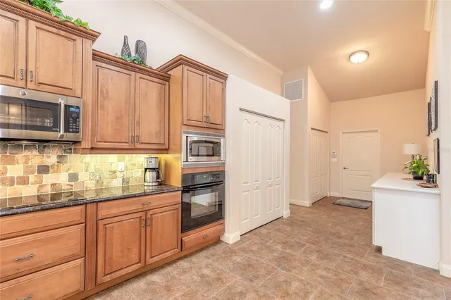 a kitchen with stainless steel appliances granite countertop a refrigerator sink and stove