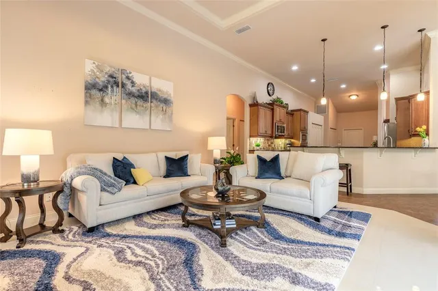a living room with furniture and kitchen view