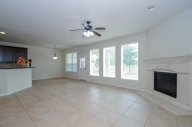 a view of an empty room with a fireplace and a window