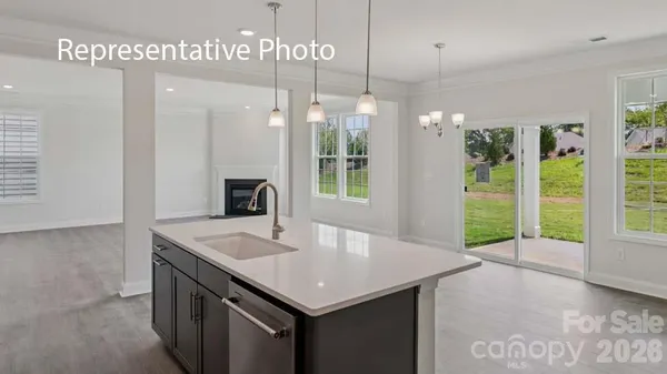 a kitchen with a sink a counter top space and living room view