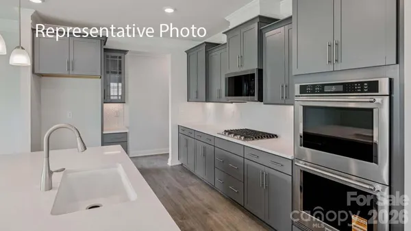 a kitchen with stainless steel appliances a stove a sink and a microwave