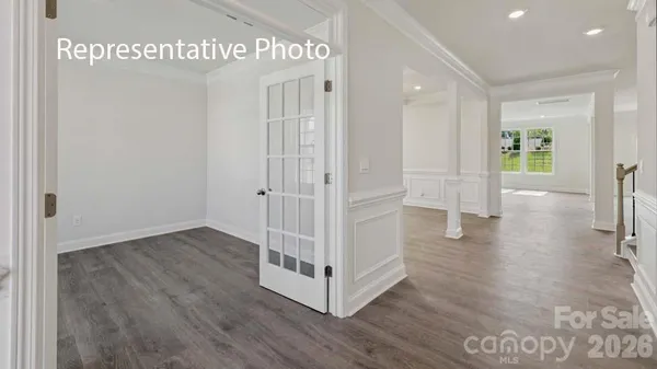 a view of a hallway with wooden floor and stairs