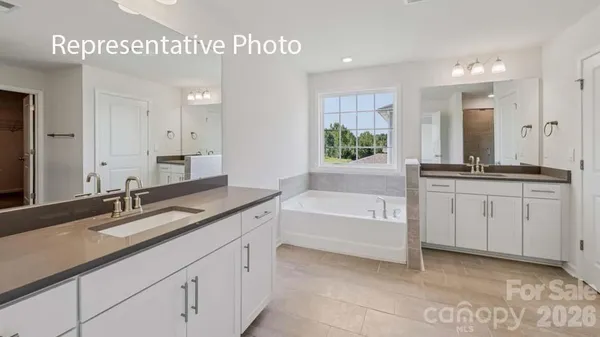 a bathroom with a granite countertop sink a large mirror and a bathtub