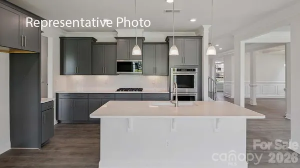 a view of living room kitchen with stainless steel appliances cabinets