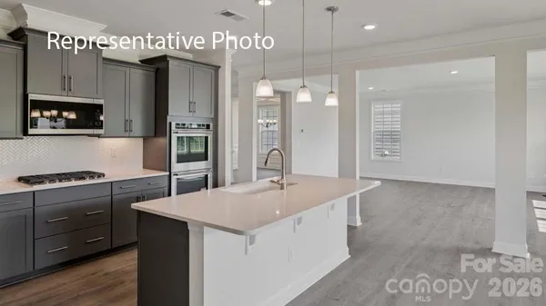 a kitchen with stainless steel appliances granite countertop a sink a stove and a refrigerator