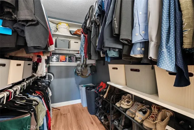 a view of walk in closet with clothes and shoes