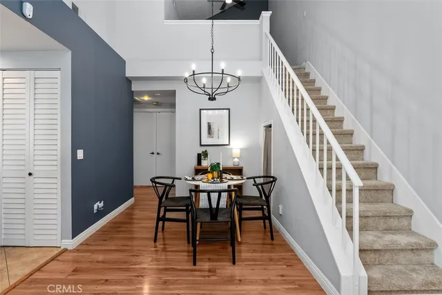 a dining room with wooden floor a chandelier a wooden table and chairs