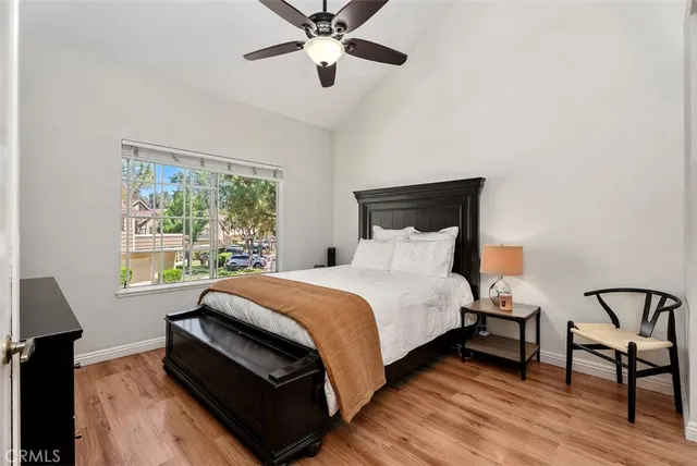 a bedroom with a bed a chandelier and a window