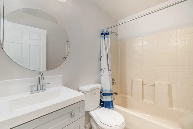 an empty room with wooden floor fan and window