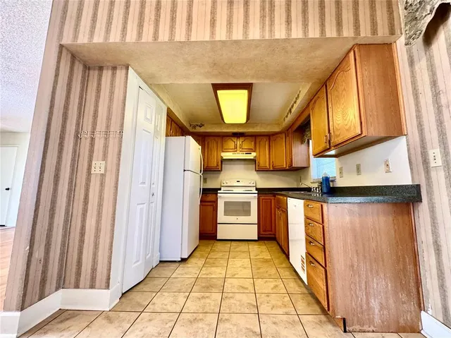a kitchen with stainless steel appliances granite countertop a refrigerator and a stove top oven