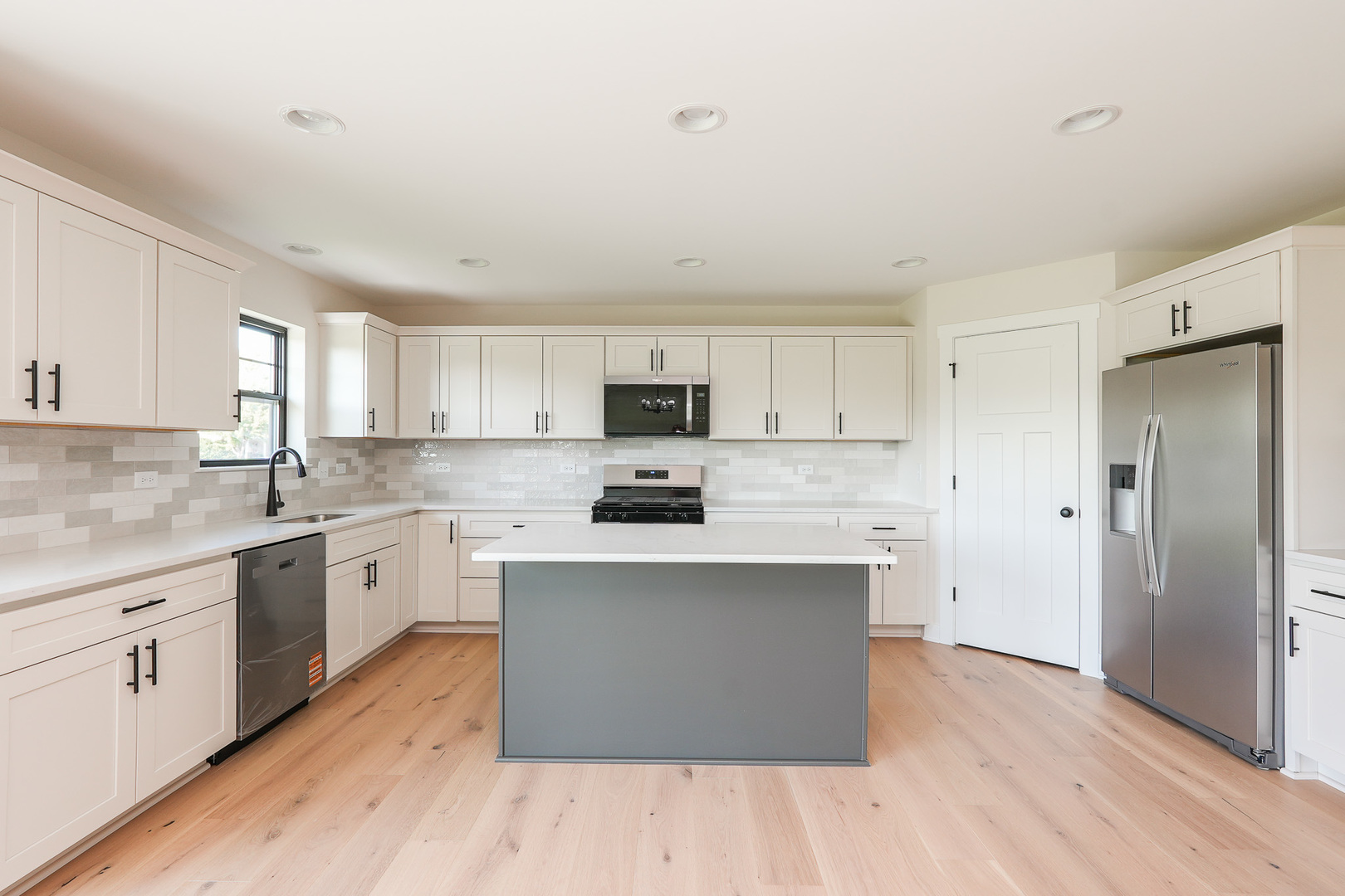 985 Spring Street Manteno, IL 60950 - Photo 19 of 46 a kitchen with stainless steel appliances granite countertop a stove top oven a sink dishwasher and a refrigerator with wooden floor