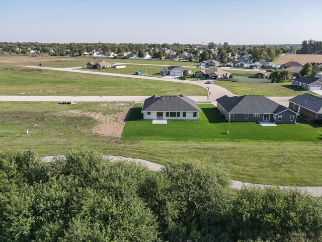 a view of a city with lawn chairs and large trees