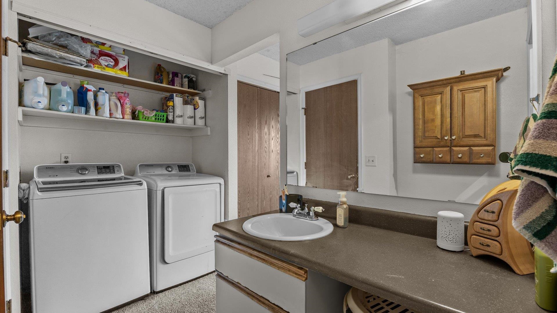 264 Coventry Court, Unit 32 Grand Junction, CO 81503 - Photo 16 of 17 a bathroom with a granite countertop sink and a washing machine