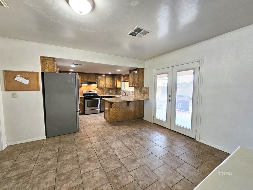 341 South Fountain Street Ridgecrest, CA 93555 - Photo 7 of 25 a kitchen with stainless steel appliances granite countertop a refrigerator and a sink