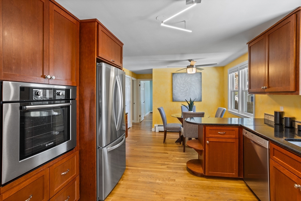 17 Hamblen Street Lexington, MA 02421 - Photo 9 of 42 a kitchen with stainless steel appliances granite countertop a refrigerator a stove top oven and a dining table