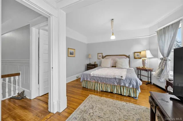a bedroom with a bed a table and a flat screen tv