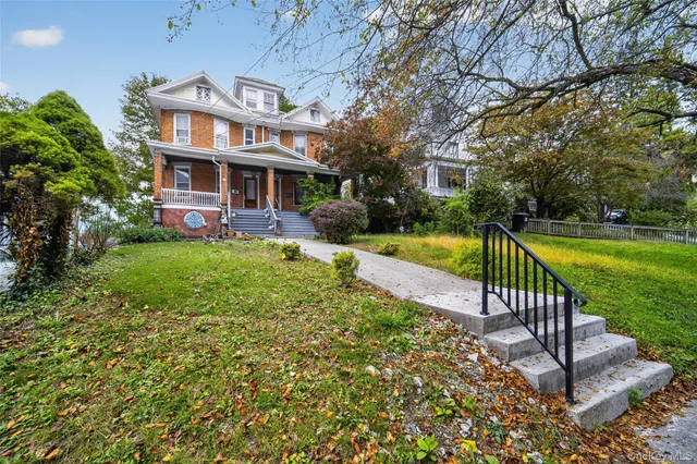 a view of a house with garden and a tree